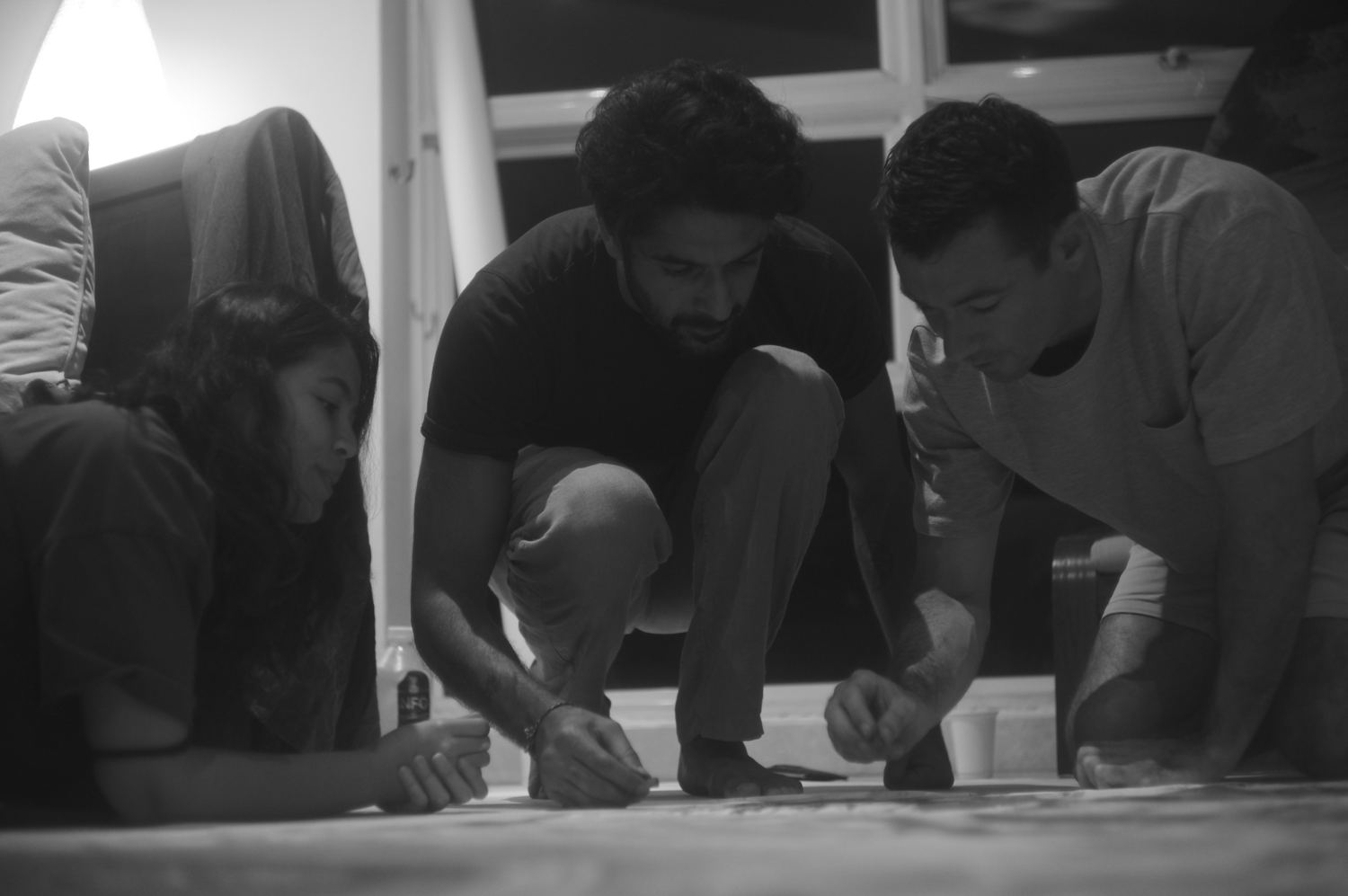 A group bent over the canvas, hands working the surface