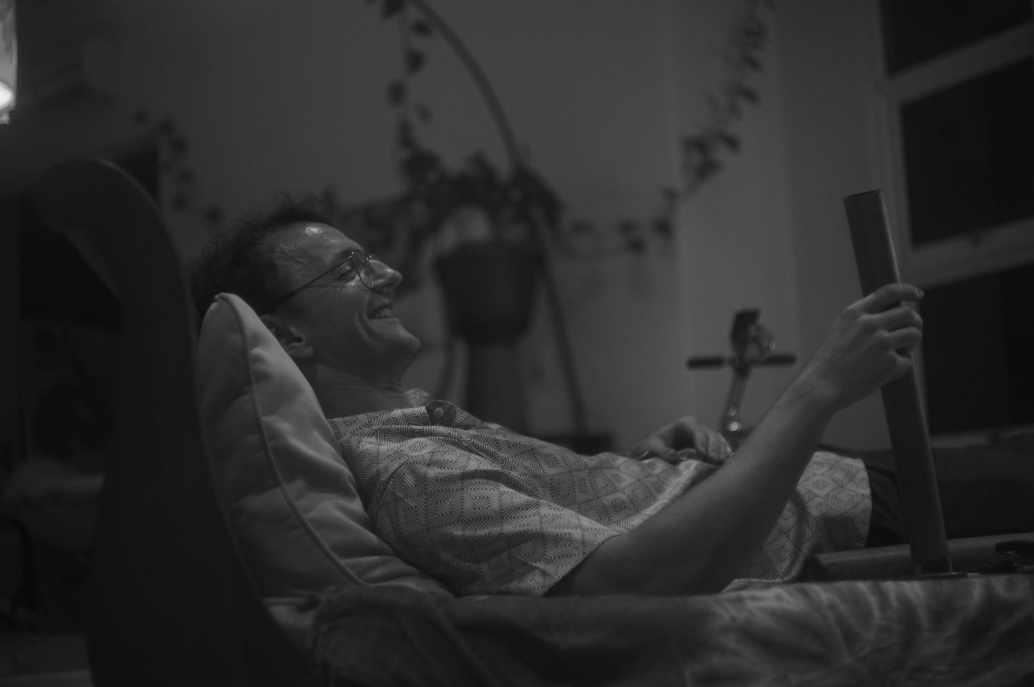 A participant lying back, laughing, holding a flute