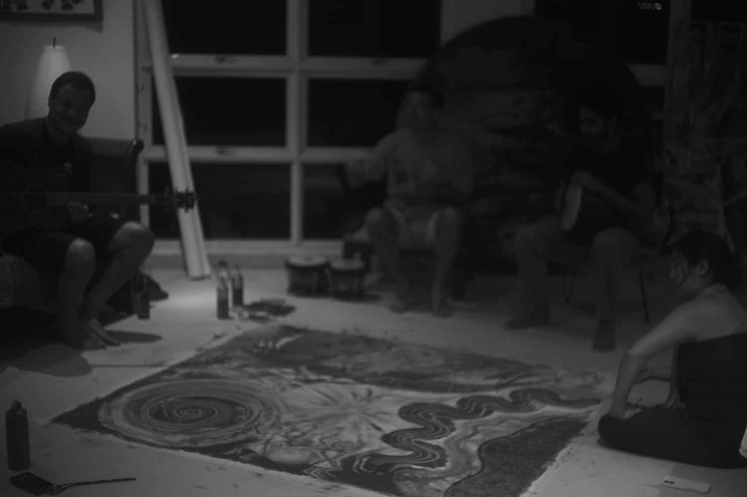 Wide view of the space, the canvas spread across the floor as the night runs on